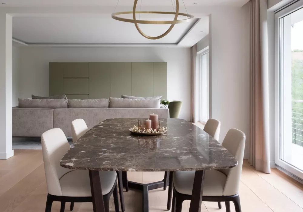 Elegantes Esszimmer in einer Privatwohnung in Köln mit Marmortisch, gepolsterten Stühlen und modernem, minimalistischen Design