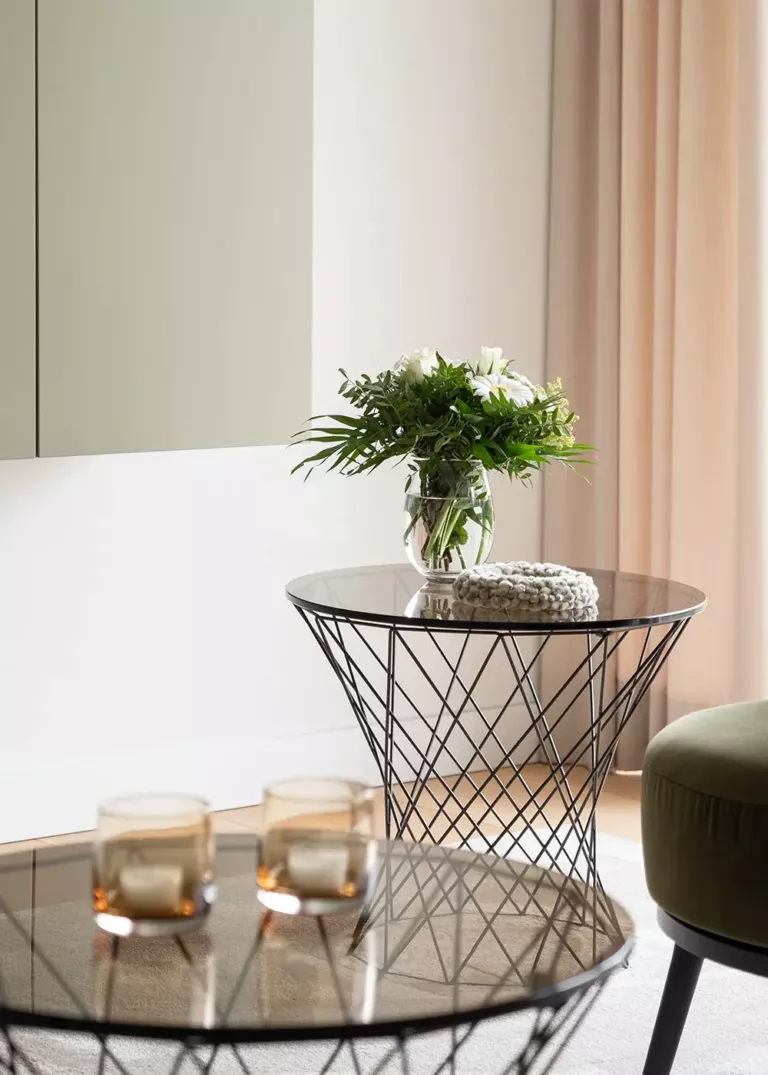 Design-Couchtische in einer Privatwohnung in Köln mit Glasplatte, filigranem Metallgestell und stilvoller Dekoration