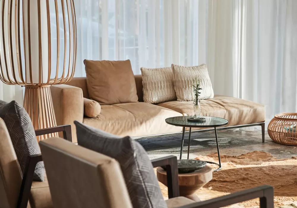 Helle und einladende Lounge im 7Pines Resort Ibiza mit bequemen Sitzmöbeln, stilvollen Holzdetails und sanftem Lichteinfall