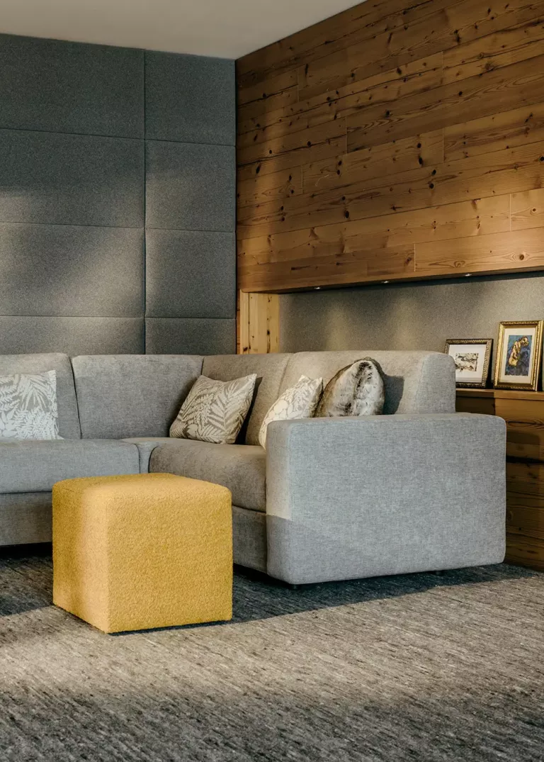 Gemütliche Lounge im Grand Tirolia Kitzbühel mit modernem Ecksofa, Holzakzenten und stilvollen Dekorationselementen