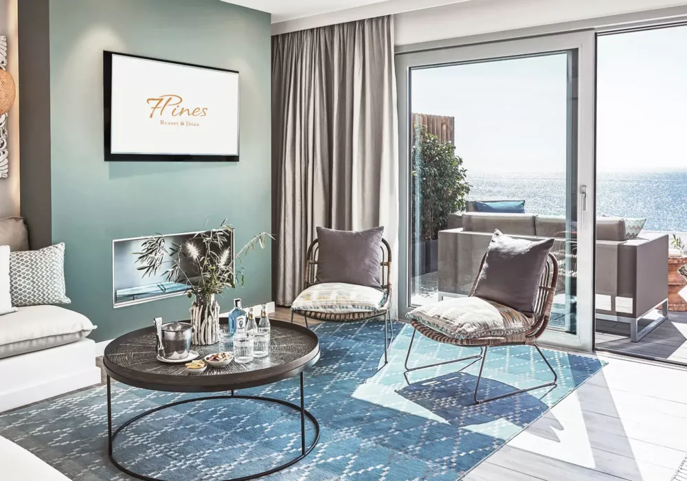 Elegantes Wohnzimmer im 7Pines Resort Ibiza mit modernem Design, stilvollen Möbeln und Meerblick von der Terrasse