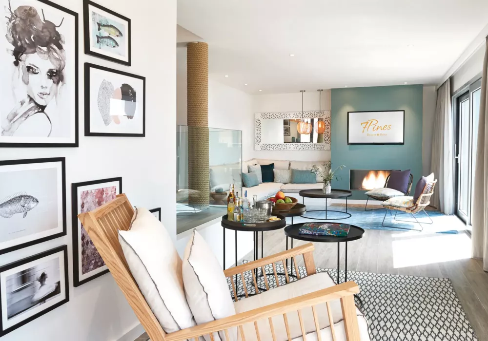 Modernes und stilvolles Wohnzimmer im 7Pines Resort Ibiza mit gemütlicher Sitzecke, Kunstgalerie an der Wand und elegantem Dekor